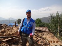 Dr. Narayan standing on rubble of a completely devastated village on outskirts of Kathmandu valley